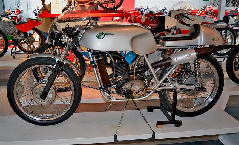 In questa MZ monocilindrica da GP raffreddata ad acqua (con circolazione a termosifone) spiccano la posizione posteriore dello scarico e la forma della marmitta a espansione. La moto &egrave; esposta al museo Poggi di Villanova di Castenaso (Bo)