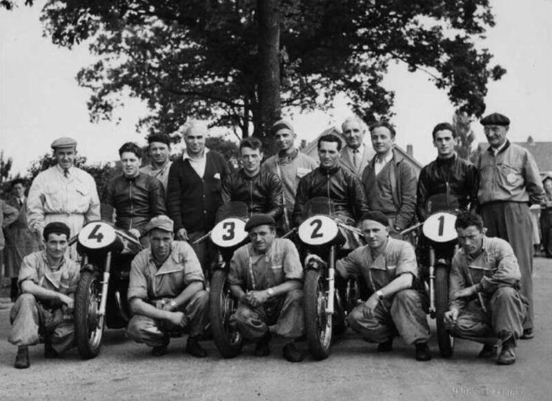 Lo squadrone Gilera ad Assen per il G.P. d&rsquo;Olanda vinto da Duke. In piedi da sinistra: Sandro Colombo, Geoff Duke, Il meccanico Cazzaniga e il direttore sportivo Piero Taruffi, Giuseppe Colnago, Ettore Villa della Catene Regina e Giuseppe Gilera. Poi Renato Guaschino, concessionario Gilera ad Asti, Umberto Masetti e Pierino Bernasconi direttore commerciale Gilera. In ginocchio il meccanico Colombo, l&rsquo;autista Galbusera ed i meccanici Fumagalli, Tremolada e Meda. Sulla numero 2, Alfredo Milani