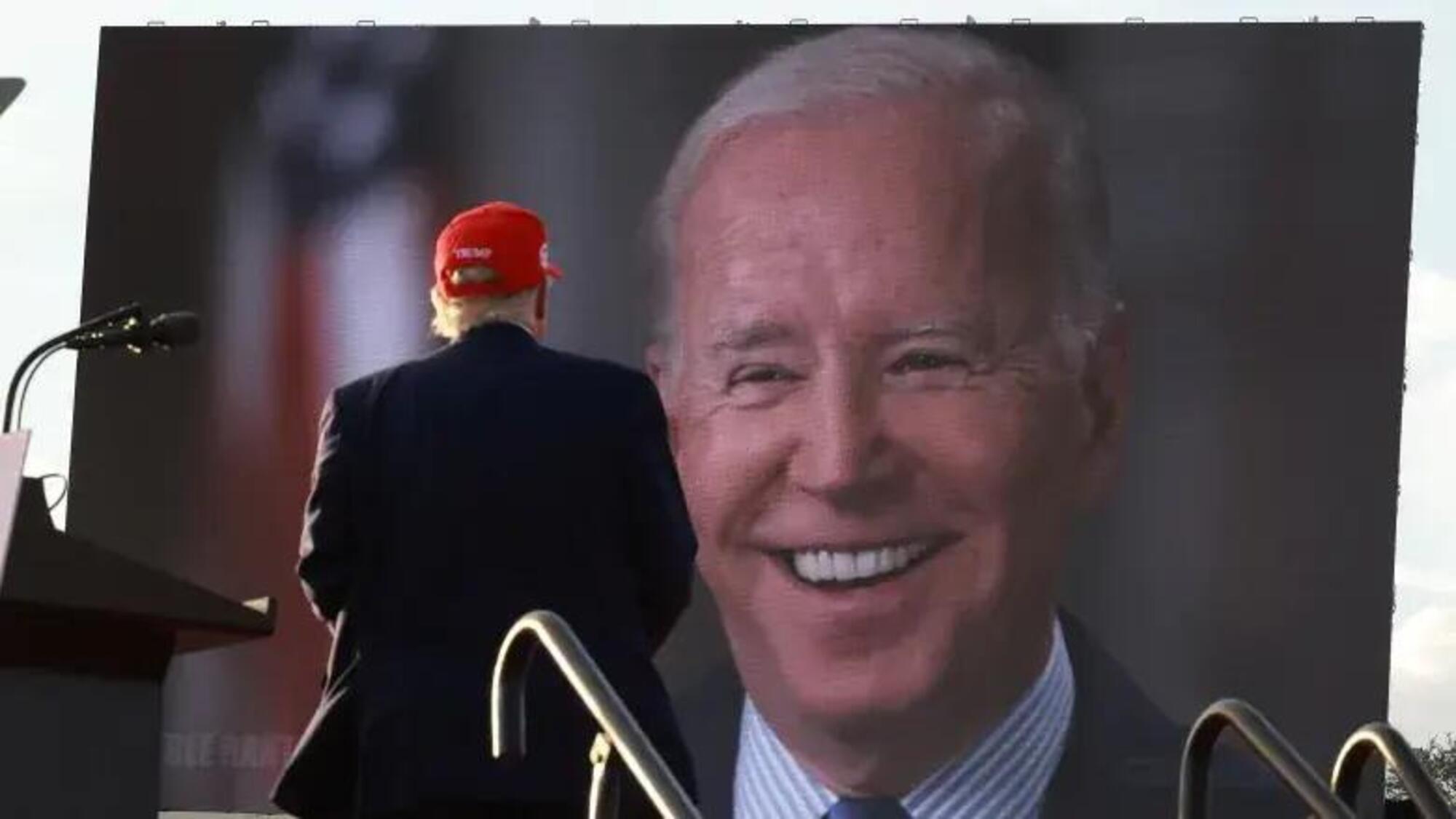 Donald Trump che guarda allo schermo Joe Biden