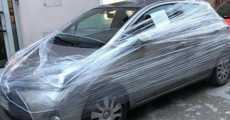 Incarta con il cellophane l&#039;auto parcheggiata davanti al suo negozio