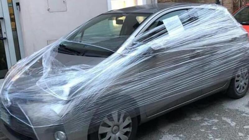 Incarta con il cellophane l&#039;auto parcheggiata davanti al suo negozio