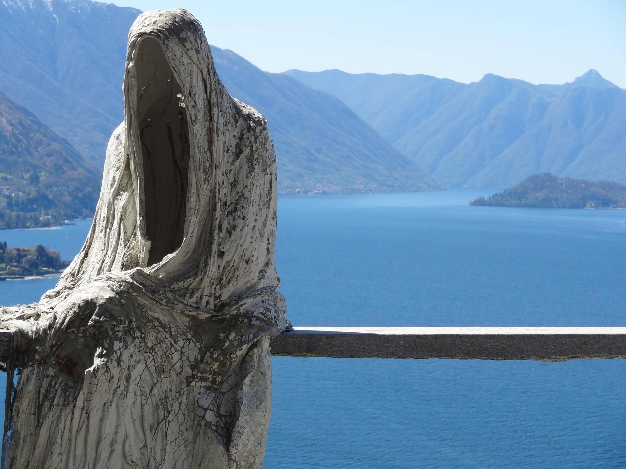 La statua di una figura senza volto sul lago di Como