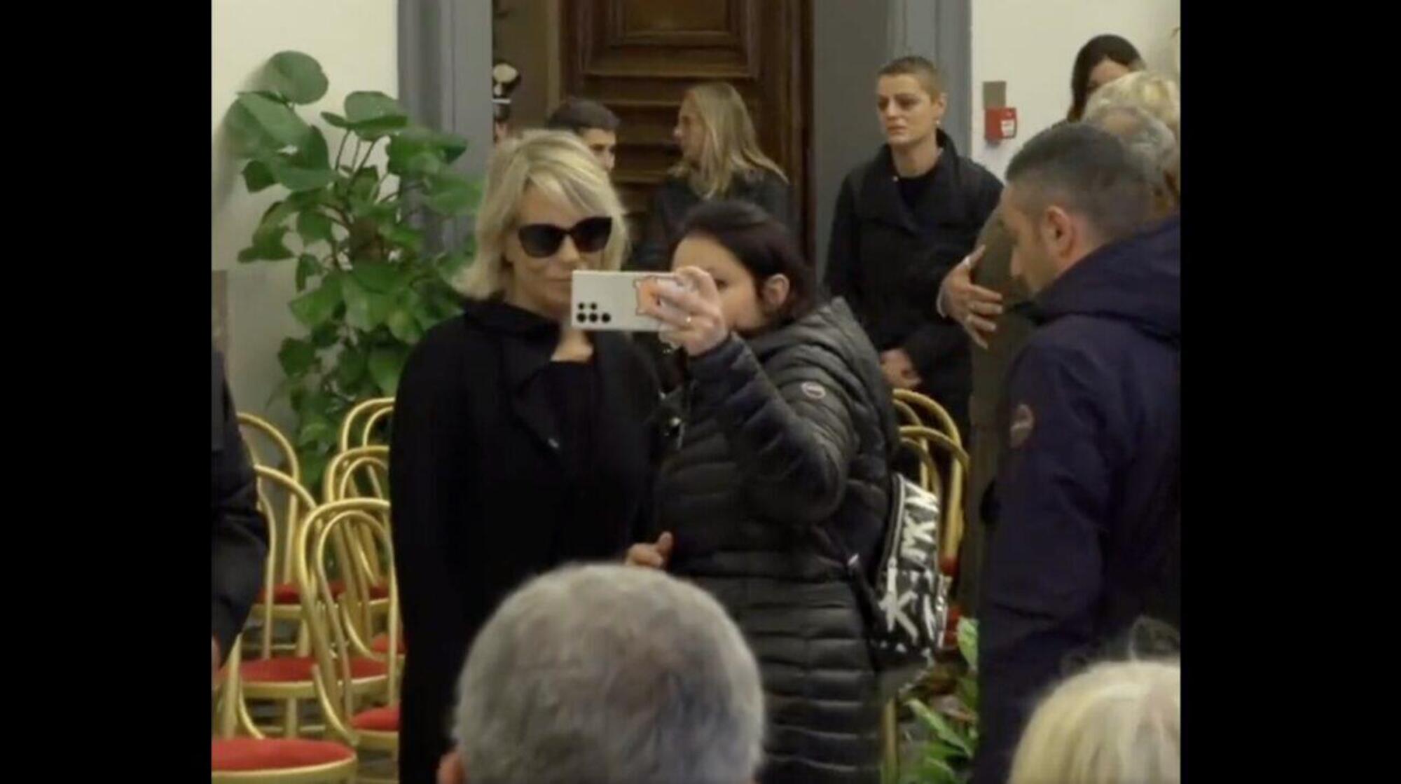 Una ragazza chiede un selfie a Maria de Filippi alla camera ardente del marito, Maurizio Costanzo