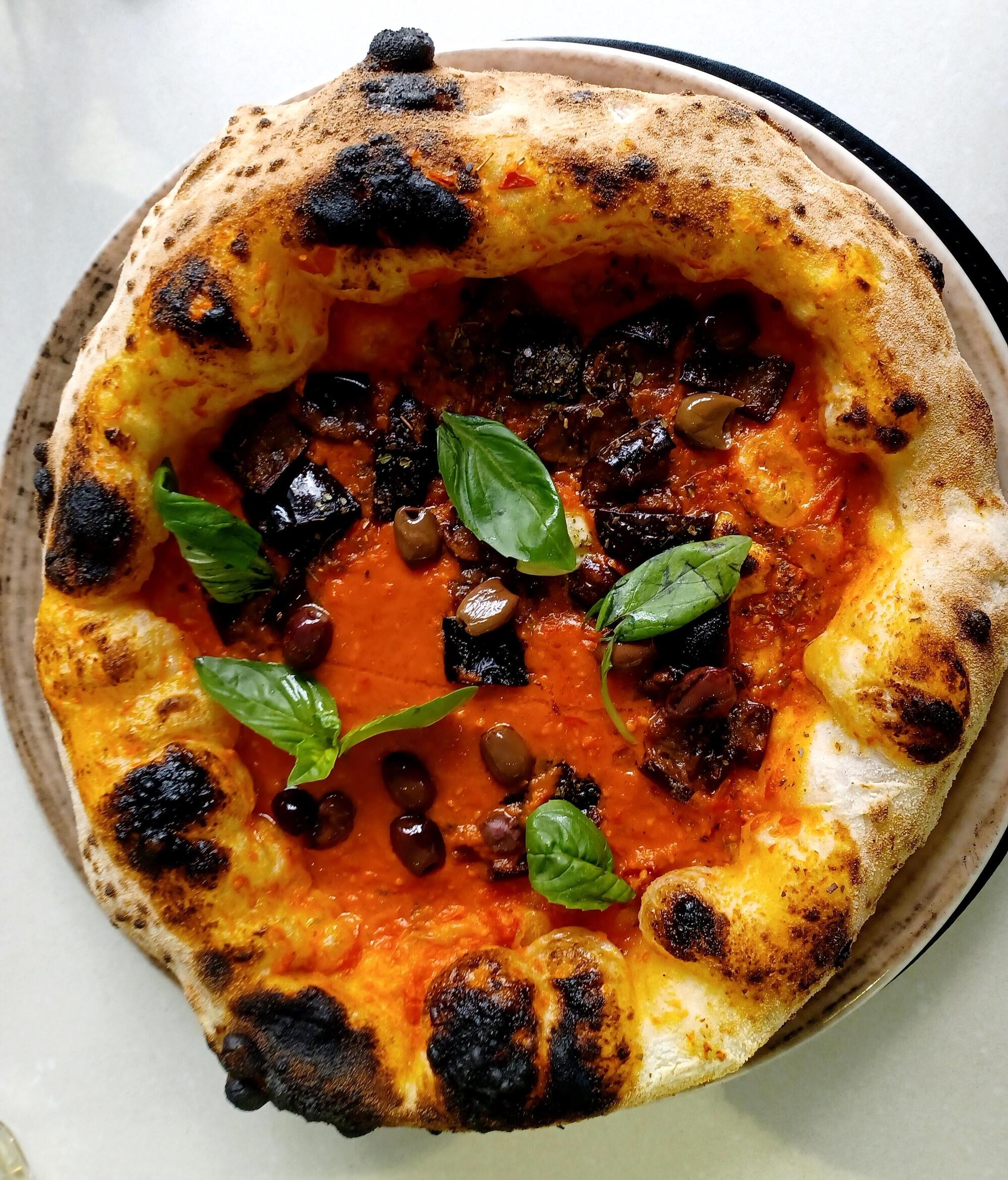 La pizza marinara con olive, basilico e melanzane