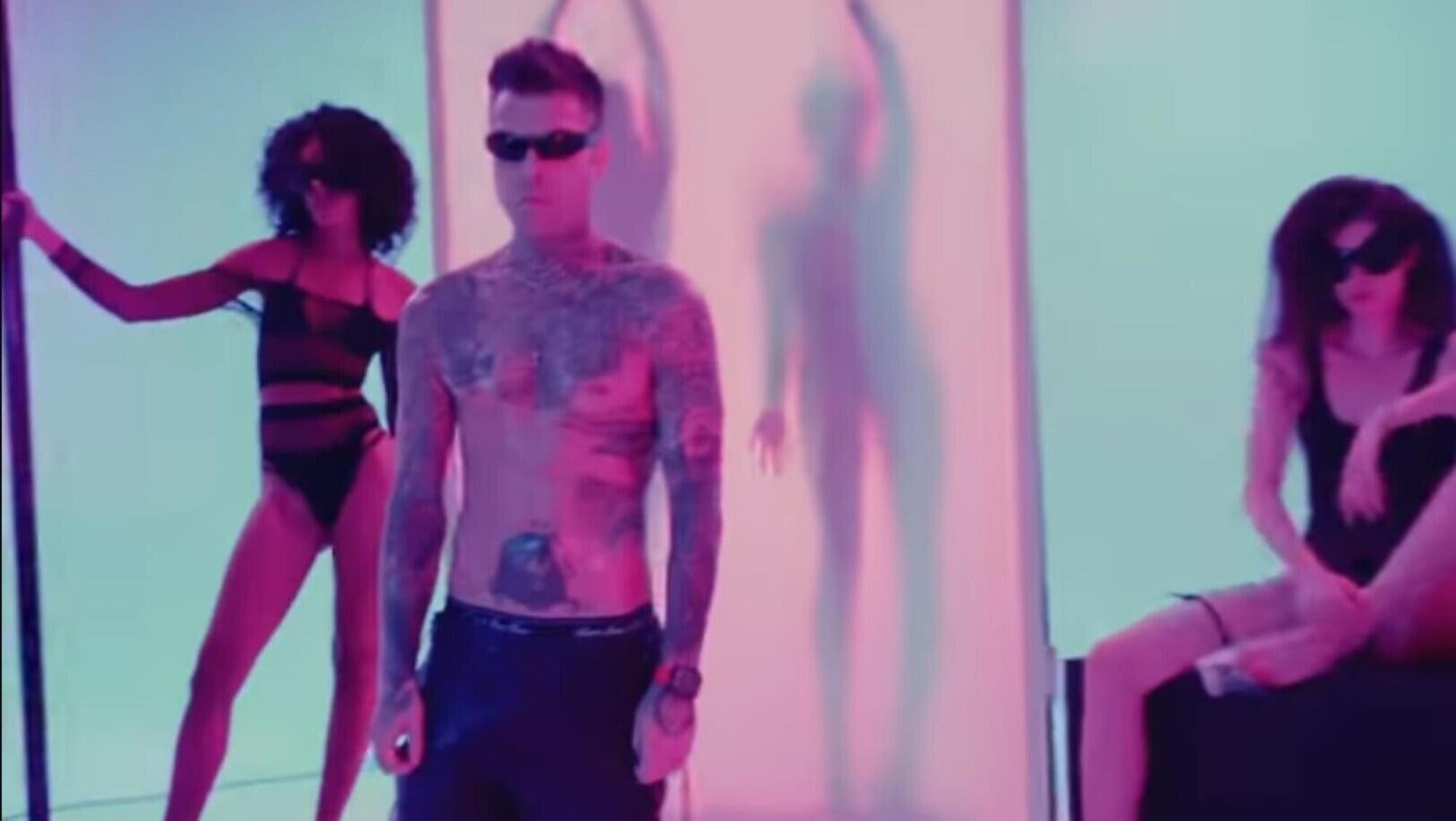 Fedez nel video musicale di Sexy Shop, un po&#039; rigido e immobile, circondato da ragazze in body