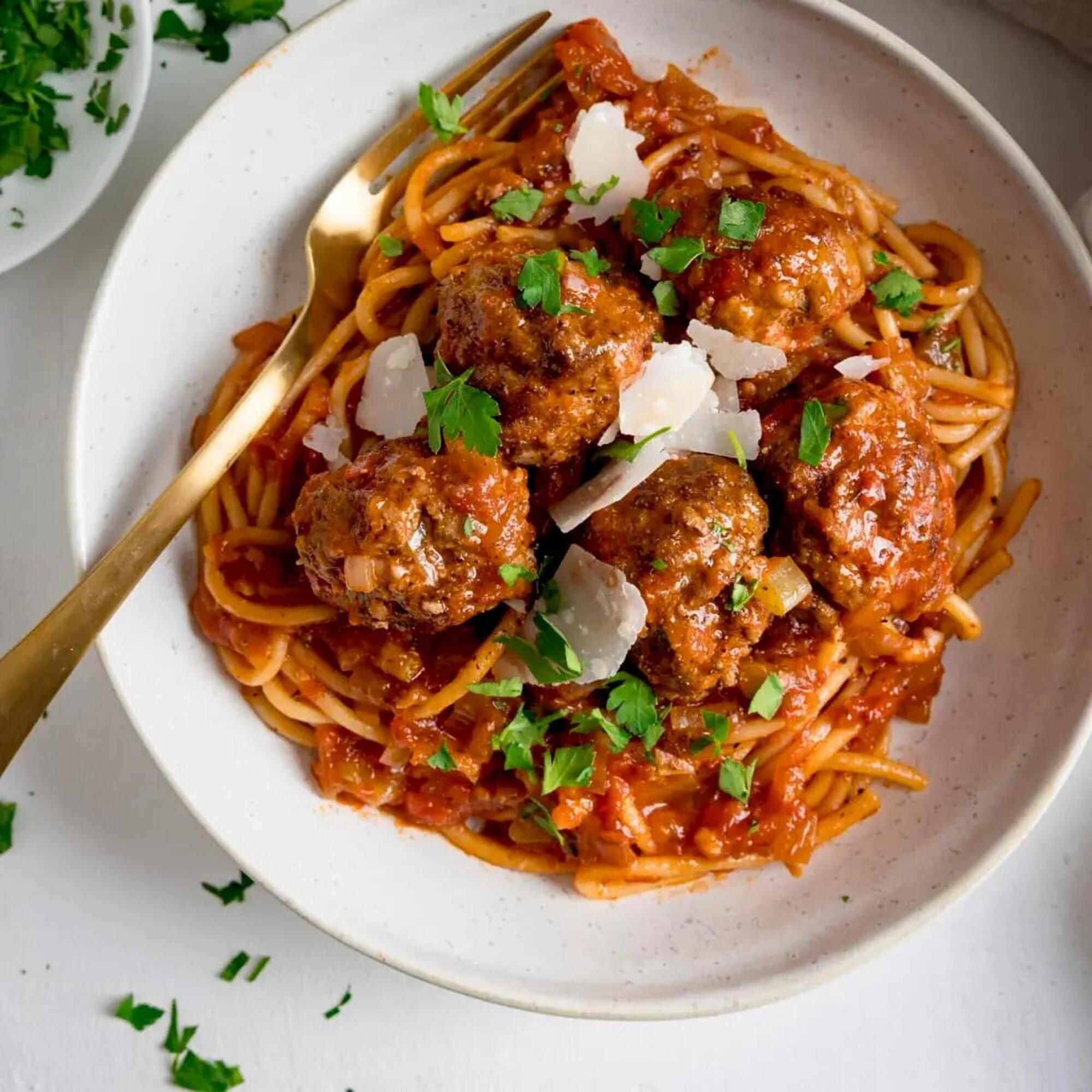 Un piatto di spaghetti with meatballs, secondo una ricetta americana, con abbondante prezzemolo
