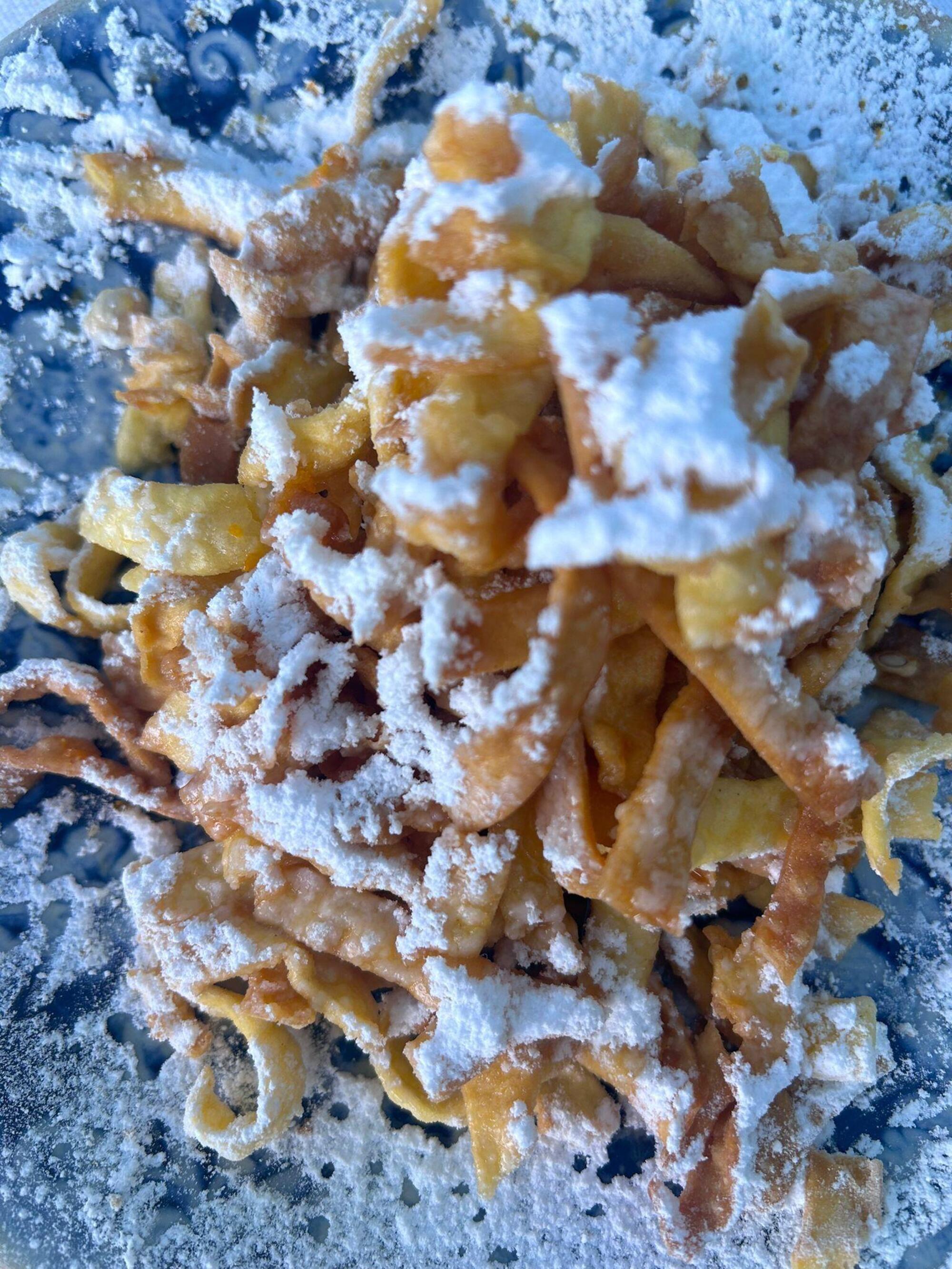 Le tagliatelle fritte con succo di arancia, zeste e zucchero a velo