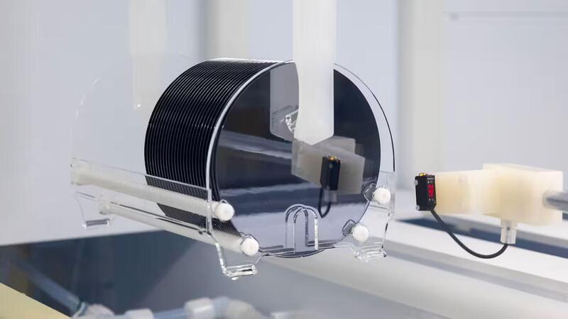Un braccio robotico sposta un wafer di semiconduttore al silicio